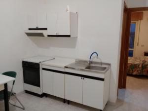 a white kitchen with a sink and a stove at La Suite in Torrevecchia Teatina