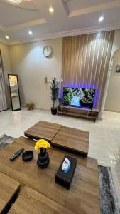 a living room with two tables in front of a tv at Rest home in Tabuk