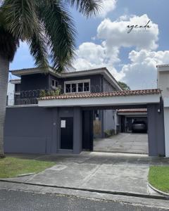 a house with a parking lot with a garage at Agenda Hotel in San Salvador