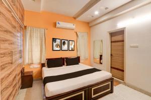 a bedroom with a large bed and an orange wall at Collection O KPHB Metro Station Hyderabad Formerly Hillside in Kukatpalli +25 photos