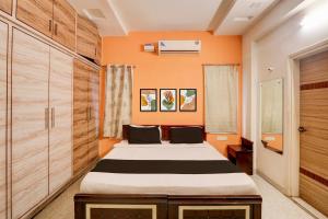 a bedroom with a bed and wooden cabinets at Collection O KPHB Metro Station Hyderabad Formerly Hillside in Kukatpalli