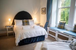 ein Schlafzimmer mit zwei Betten und zwei Fenstern in der Unterkunft Hill House 2 in Caton