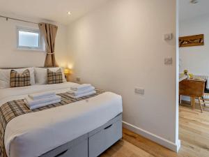 a bedroom with a large bed with towels on it at 1 Bed in Aberaeron 95972 in Aberaeron