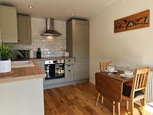a kitchen with a table and chairs and a kitchen with a stove at 1 Bed in Aberaeron 95972 in Aberaeron
