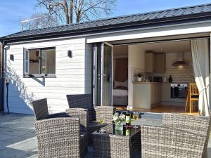 a house with chairs and a table on a patio at 1 Bed in Aberaeron 95972 in Aberaeron