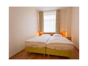 een bed in een kamer met een groot raam bij Suurhusen - Greetsiel in Greetsiel