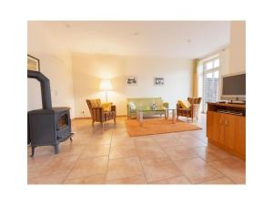 een woonkamer met een open haard en een fornuis bij Suurhusen - Greetsiel in Greetsiel