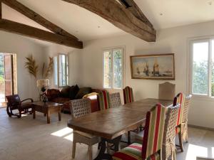Una sala de estar con una mesa y sillas de madera. en villa bormes les mimosas, en Bormes-les-Mimosas