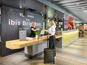 two women standing at a counter in a restaurant at ibis Brighton City Centre - Station in Brighton & Hove