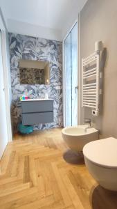a bathroom with two toilets and a stone wall at Appartamento tra mare e montagna in Castel di Lama