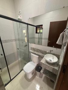a bathroom with a toilet and a sink and a shower at Recanto Vale Minã in Lavrinhas