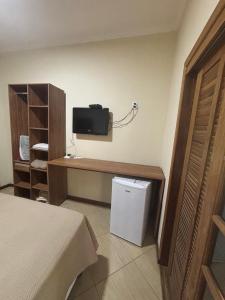 a room with a bed and a tv on the wall at Recanto Vale Minã in Lavrinhas