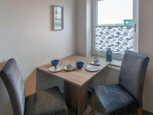 Una mesa de comedor con dos sillas y una ventana. en Holiday apartment Osterloog-Norddeich, en Norddeich 3 fotos más