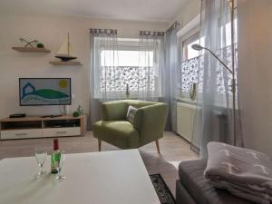 una sala de estar con un sofá y una silla en Holiday apartment Osterloog-Norddeich, en Norddeich