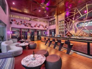 un restaurante con un bar con sillas y un mostrador en Pullman Bali Legian Beach, en Legian