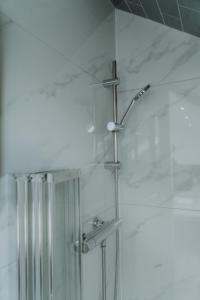 een douche in een badkamer met witte marmeren muren bij Urban Luxury in Colnbrook