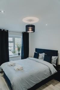 een slaapkamer met een groot bed met handdoeken erop bij Urban Luxury in Colnbrook