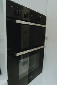 een zwarte oven in een keuken met een muur bij Urban Luxury in Colnbrook