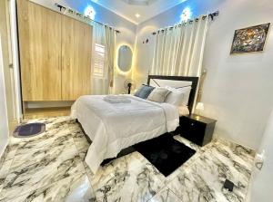 a bedroom with a large bed and a marble floor at Cozy Corners in Iseri-Oke