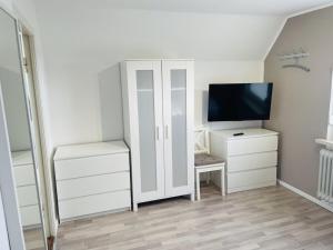 1 dormitorio con armario blanco y TV en Holiday home with 3 bedrooms, en Norddeich