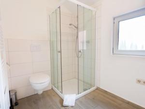 Un baño con inodoro y ducha de cristal. en Holiday home with 3 bedrooms, en Norddeich 20 fotos más