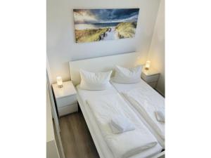 Dos camas en una habitación con un cuadro en la pared. en Holiday home with 3 bedrooms, en Norddeich