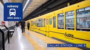ein gelber Zug in einem Bahnhof mit Menschen, die daneben gehen in der Unterkunft Deluxe Apartments in Downtown by BueRentals in Buenos Aires + 25 Fotos