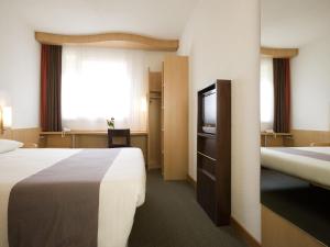Una habitación de hotel con dos camas y un televisor. en Ibis Cotonou, en Cotonou 57 fotos más