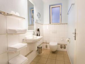 een witte badkamer met een toilet en een wastafel bij Twixlum - Greetsiel in Greetsiel