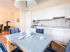 een keuken met witte kasten en een blauw aanrecht bij Twixlum - Greetsiel in Greetsiel +9 foto's