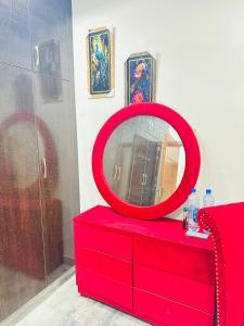 a red dresser with a red mirror on top of it at Flat in wah cantt in Wāh