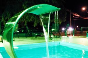 a water fountain in a swimming pool at night at CASA CON PISCINA para alojar a toda la familia in Pântano Grande