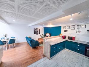 a kitchen with blue cabinets and a living room at Duplex moderne au cœur de Saverne in Saverne