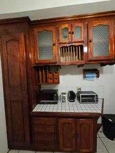 a kitchen with wooden cabinets and a counter top at The Carnival Residence at Queens Park Savannah in Valencia Village