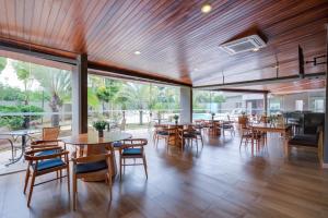 a dining room with tables and chairs and large windows at Quality Hotel Jundiaí in Jundiaí