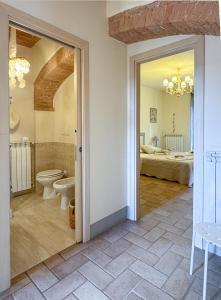 a bathroom with a toilet and a bedroom at CLAUDIA VACANZA TOSCANA - Appartamento Melograno -10 min da Siena in Sovicille