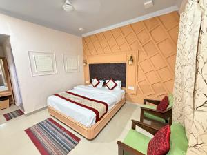 a hotel room with a bed and a chair at Hotel Amar in Mussoorie