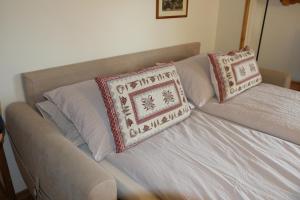 un divano con due cuscini sopra di Appartamento Rin, Livigno a Livigno Altre 15 foto