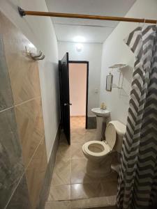 a bathroom with a toilet and a walk in shower at Apartamentos Coveñas TII in Coveñas