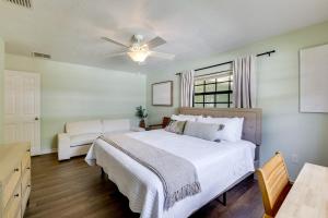 a bedroom with a white bed and a ceiling fan at Bring Your Boat! Canal-Front Tavares Home with Dock in Tavares