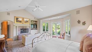a bedroom with a bed and a living room with a fireplace at Vineyard Estate w Pool Spa Bocce Ball Mins to Wineries Park Lawndale Road by AvantStay in Lawndale
