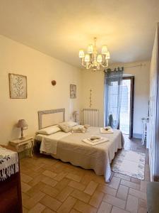 a bedroom with two beds and a chandelier at CLAUDIA VACANZA TOSCANA - Appartamento Melograno -10 min da Siena in Sovicille