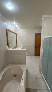 Un baño con bañera, lavabo y espejo. en Countryside Retreat, en Peralillo