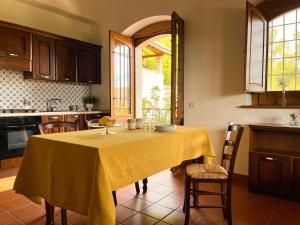 a kitchen with a table with a yellow table cloth at Le Conche country house in Villamaina