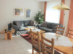 a living room with a table and a couch at Holiday apartment with 2 bedrooms in Wursterheide