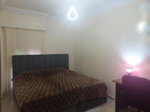 a bedroom with a bed and a light on the wall at Kerouch house in Temara
