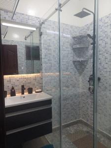a bathroom with a sink and a glass shower at Kerouch house in Temara