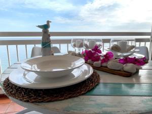 a table with plates and bowls on top of a balcony at Estrela do Mar - Ocean View Apartment - Sesimbra - Falésia in Sesimbra