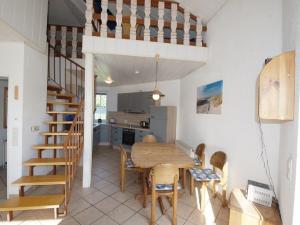 a kitchen and dining room with a wooden table and chairs at 1-bedroom holiday home in Dorum Neufeld