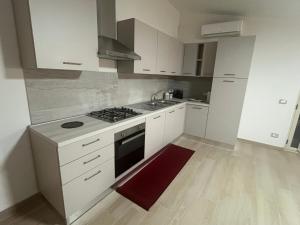 une cuisine blanche avec une cuisinière et un évier dans l'établissement Kalon Eidos, il magico posto della Calabria Jonica, à Condofuri Marina